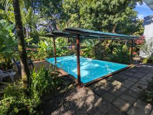 a pool with a gazebo next to a swimming pool at Arbura in Uvita