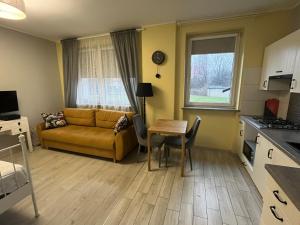 een woonkamer met een bank en een tafel bij Apartament COMFORT Centrum in Krotoszyn