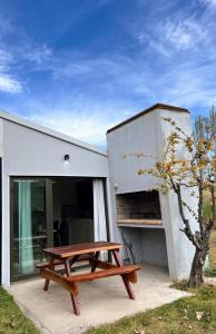 einem Picknicktisch aus Holz vor einem Gebäude in der Unterkunft Finca La Escondida San Rafael in San Rafael