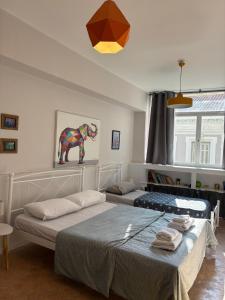 a bedroom with two beds and a painting of a elephant at Acropolis Ermou Rooms at Plaka in Athens