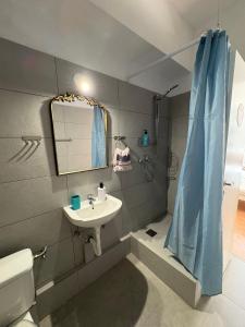 a bathroom with a sink and a shower with a mirror at Acropolis Ermou Rooms at Plaka in Athens