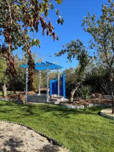 ein blauer Unterstand in einem Park mit grünem Gras in der Unterkunft Victoria Plum in Cropthorne