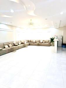 een wachtkamer met banken en een kroonluchter bij شاليهات ميرا in Taif +20 foto's