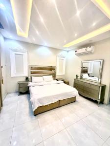 een slaapkamer met een groot bed en een grote spiegel bij شاليهات ميرا in Taif