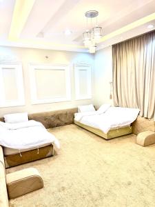 twee bedden in een kamer met twee ramen bij شاليهات ميرا in Taif