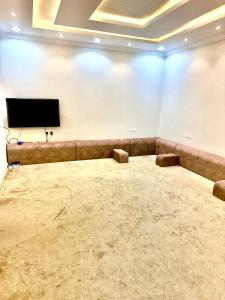 een lege kamer met een flatscreen-tv aan de muur bij شاليهات ميرا in Taif