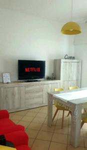 una cucina con TV, tavolo e sedie di ᑕᗩSᗩ ᗰᗩᖴᗩᒪᗪᗩ Vicino alla stazione e al centro storico, posto auto interno a Imola