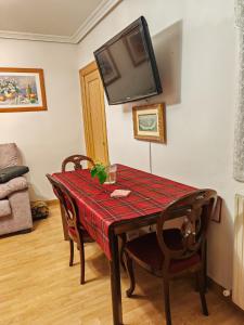 een eettafel met een televisie aan de muur bij VIRGEN de ALFILERITOS in Toledo
