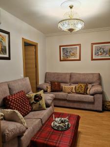 een woonkamer met een bank en een kroonluchter bij VIRGEN de ALFILERITOS in Toledo