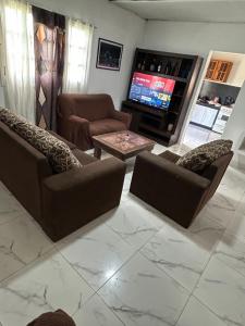 een woonkamer met 2 banken en een televisie bij Casa in Miramar