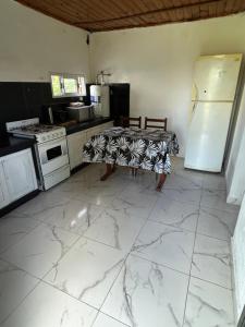 een keuken met witte marmeren vloeren en een koelkast bij Casa in Miramar