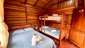 a bedroom with two bunk beds in a cabin at Paraiso Orquideario in Baños