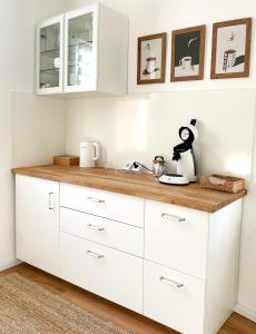 eine Küche mit weißen Schränken und einer Holzarbeitsplatte in der Unterkunft green rooms in Schweinfurt