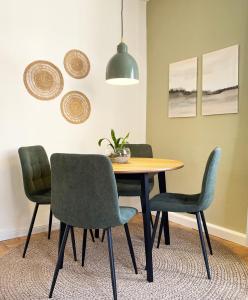 ein Esszimmer mit einem Tisch und vier Stühlen in der Unterkunft green rooms in Schweinfurt