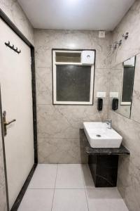 een badkamer met een wastafel en een raam bij Ocean Regency in Ujjain