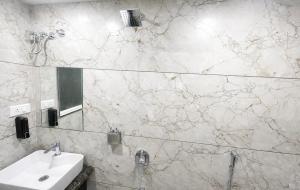 een badkamer met een wastafel en een spiegel bij Ocean Regency in Ujjain