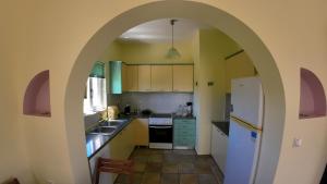 een boog in een keuken met een wastafel en een koelkast bij Ze Di Ma House in Kýthira