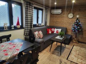 a living room with a couch and a christmas tree at Chata Bosorečka in Smižany +33 photos