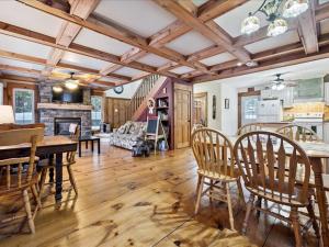 een woonkamer met een tafel, stoelen en een open haard bij 3 Bears Cottage by Lake Huron in Red Bay +10 foto's