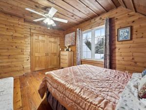 een slaapkamer met een bed en een plafondventilator bij 3 Bears Cottage by Lake Huron in Red Bay
