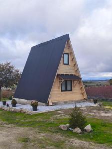 ein Haus mit einem schwarzen Dach darüber in der Unterkunft Chalé da Cumieira Nova in Seia