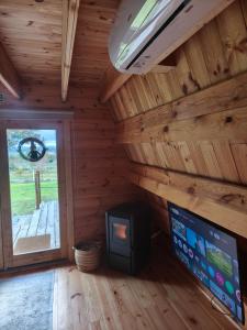 Ein Zimmer in einer Blockhütte mit Kamin und Fernseher in der Unterkunft Chalé da Cumieira Nova in Seia