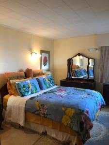 a bedroom with a bed and a large mirror at Coppelia Sunrise in Omokoroa