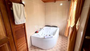 a bathroom with a tub and a toilet at Paraiso Orquideario in Baños