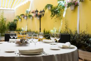 a table with wine glasses and plates on it at Sercotel Avenida Almería in Almería +28 photos