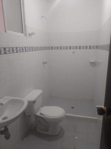 une salle de bains blanche avec toilettes et lavabo dans l'établissement Barbara León, à Simacota