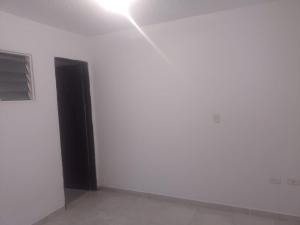 een lege kamer met een witte muur en een raam bij Barbara León in Simacota