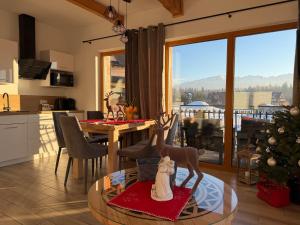 a kitchen and living room with a christmas tree and a table at Osada domków Baca in Poronin