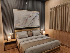 a bedroom with a bed with a large painting above it at Sunrise Vista Resort & Hotel in Bāgeshwar