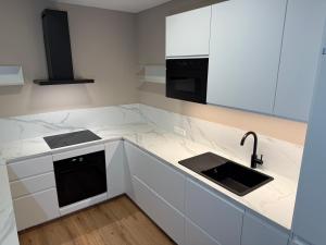 a kitchen with white counter tops and a sink at "Haus im Grünen" Ferienhaus mit Sauna direkt am Ossiacher See und an der Gerlitzen Alpe in Bodensdorf
