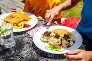 een groep mensen aan een tafel met borden eten bij Ferienhaus mit Sauna direkt am Ossiacher See und an der Gerlitzen Alpe in Bodensdorf