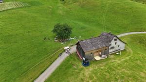 un gruppo di persone in piedi attorno a un fienile in un campo di Bräkerhaus Toggenburg a Lichtensteig