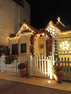 una casa con luci di Natale e una staccionata bianca di Trullo Di Tagaro a Locorotondo