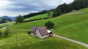 una piccola casa in un campo di erba verde di Bräkerhaus Toggenburg a Lichtensteig