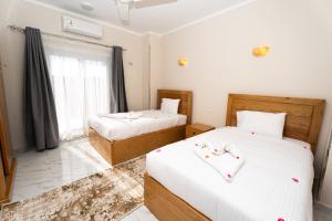 a bedroom with two beds and a window at Villa Ramses in Luxor