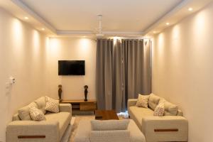 a living room with two couches and a tv at Villa Ramses in Luxor