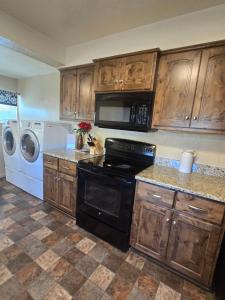 een keuken met houten kasten en een zwarte kachel bij Bryce 2 bedroom home in Tropic