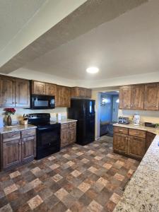 een keuken met zwarte apparatuur en houten kasten bij Bryce 2 bedroom home in Tropic