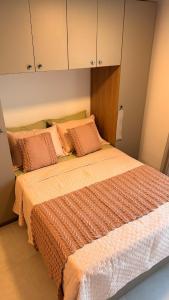 a bedroom with a bed with orange and white sheets and cabinets at Beira Mar - Melhor Localização Bessa Five in João Pessoa +21 photos