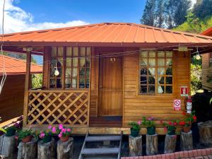 a small wooden house with an orange roof at Paraiso Orquideario in Baños