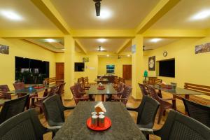 ein Restaurant mit Tischen und Stühlen in einem Raum in der Unterkunft Dandeli Tiger Cottages in Dandeli