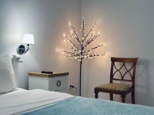 a bedroom with a bed and a tree with lights at Апартаменти La Storia in Kamianets-Podilskyi