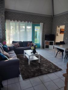 un soggiorno con un divano e un tavolo di Gemütliches, komfortables Ferienhaus a Schoorl Altre 2 foto