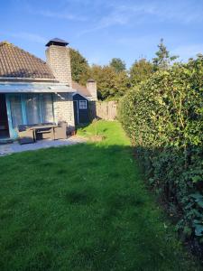 un cortile accanto a una casa con un prato sidx sidx di Gemütliches, komfortables Ferienhaus a Schoorl