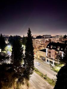 Blick auf eine Stadtstraße mit Bäumen und Gebäuden in der Unterkunft Gorica Hill Luxury Residence in Podgorica
