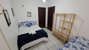 a small bedroom with a bed and a shelf at Residencial DO MAR in Bombinhas